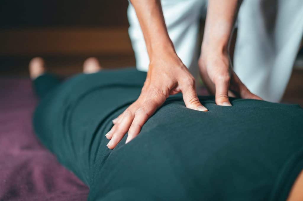 Women hands working a person laying down sore muscles